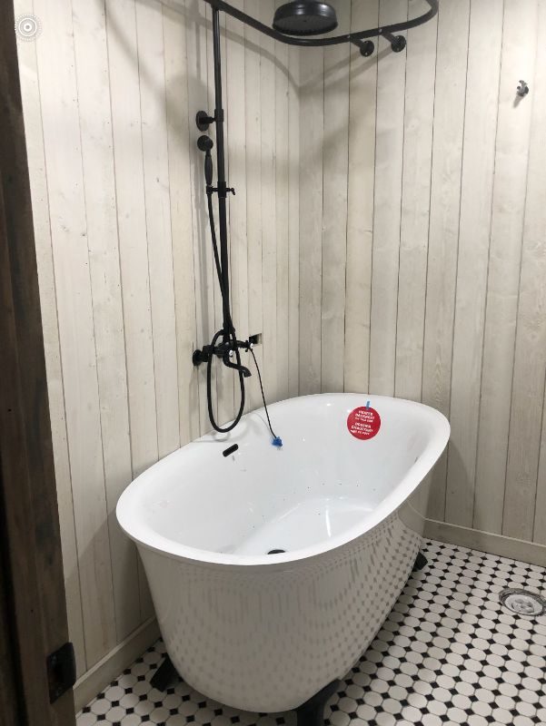 Clawfoot tub with shiplap walls and black fixtures — West Babylon, NY