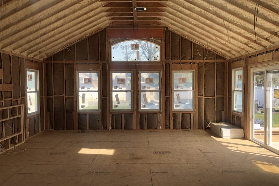 New second floor framing in a Long Island addition with insulated rafters, a wall of new Andersen windows and a plywood subfloor, by Just Enterprise One Corp.