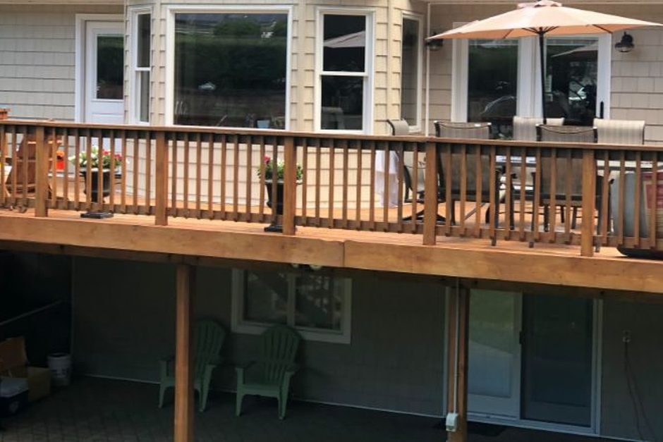 Elevated wood deck with a code height guard railing on a Long Island home, built by Just Enterprise One Corp.