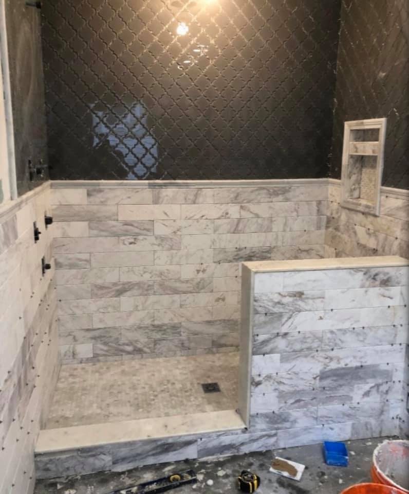 Arabesque mosaic tile shower wall being installed