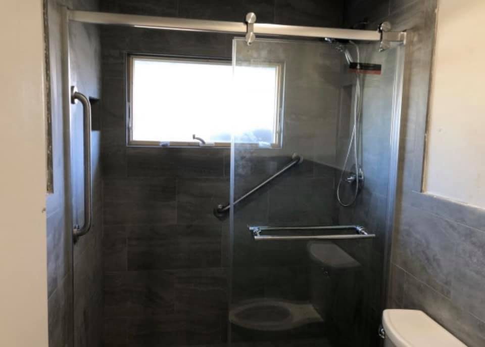 Dark gray tile shower with frameless glass slider door