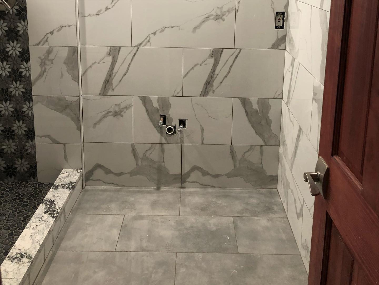 Marble tile bathroom with floral mosaic accent strip