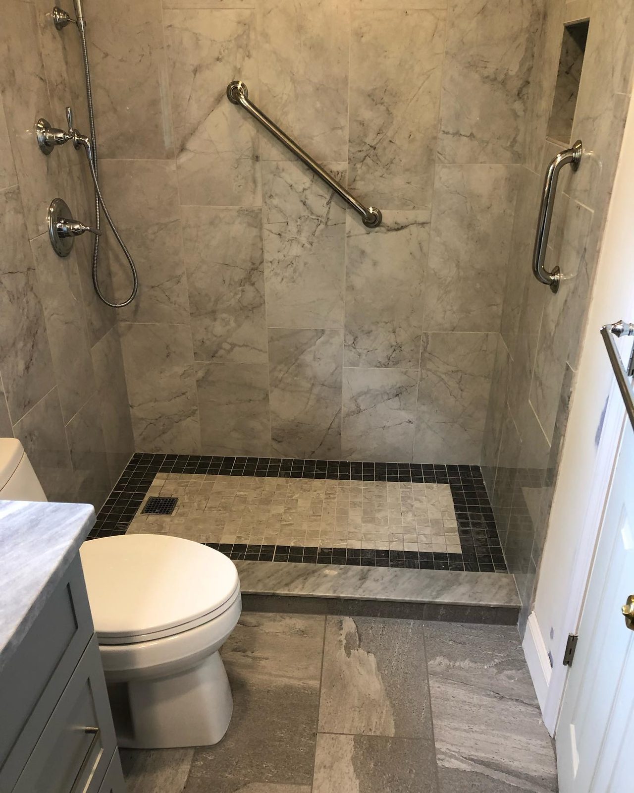 Accessibility bathroom — marble tile shower with grab bars