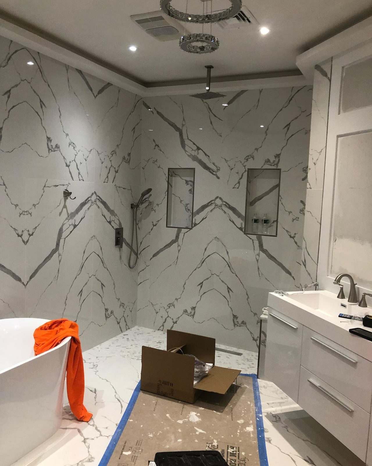 Marble walk-in shower with frameless glass enclosure
