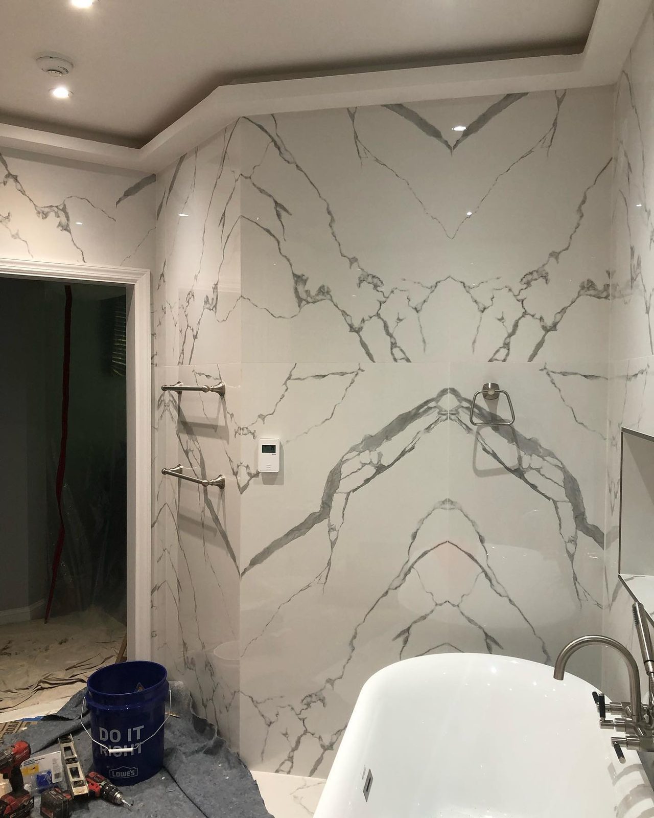 Marble tile bathroom with double vanity and backlit mirror
