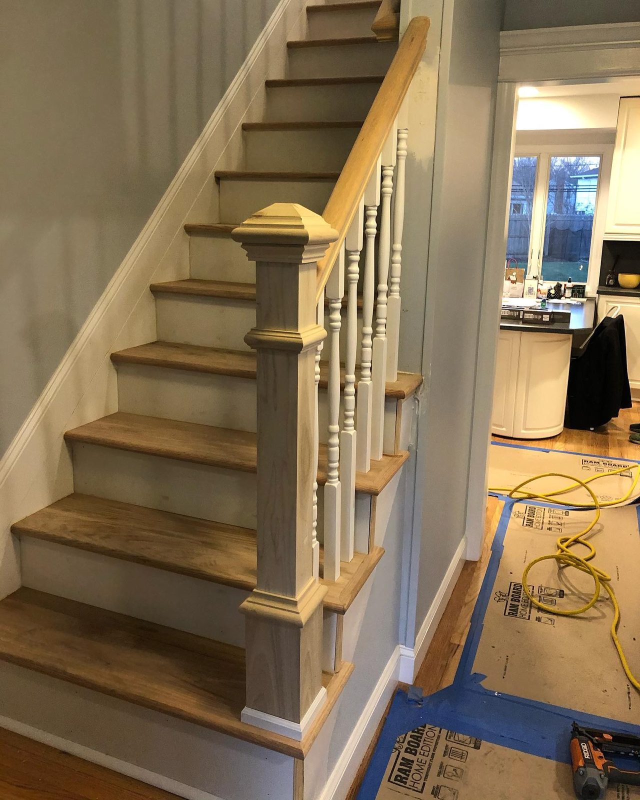 Staircase renovation with natural wood treads and new railings