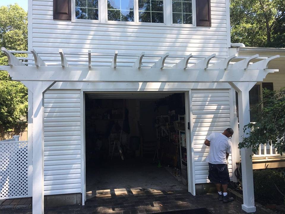 White painted pergola built over garage with decorative trim