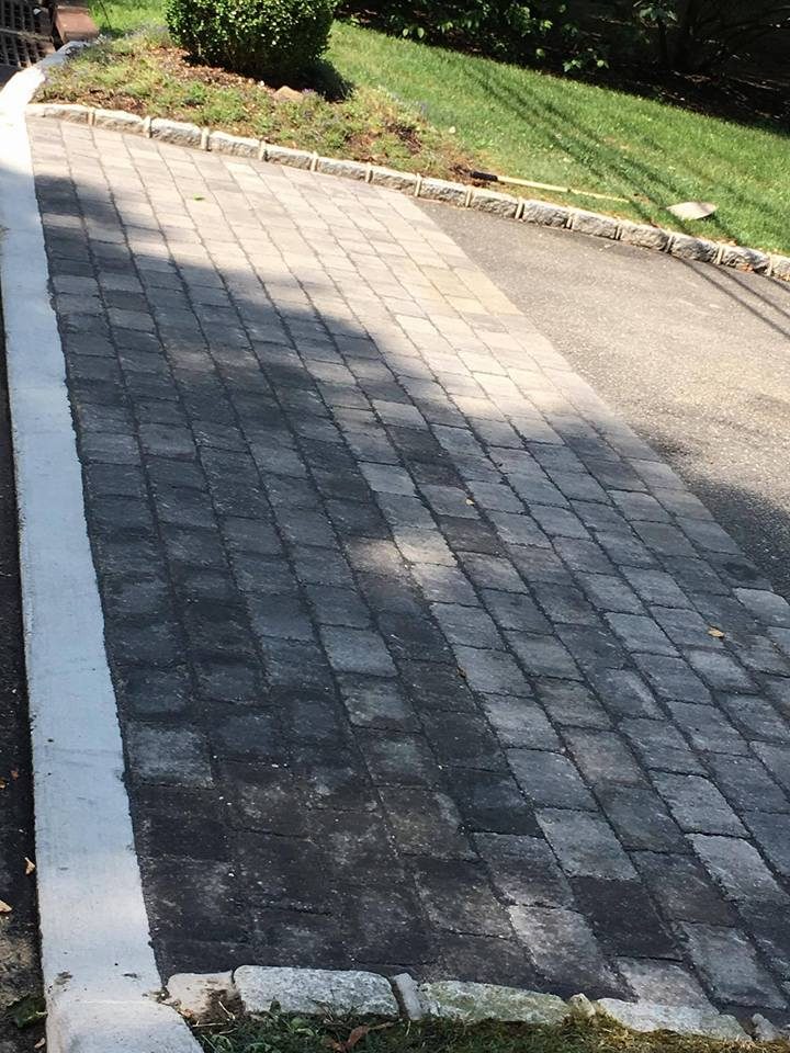 Dark cobblestone paver driveway installation