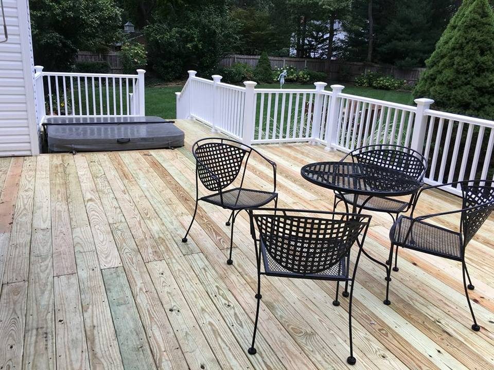 Wood deck with built-in hot tub and railing