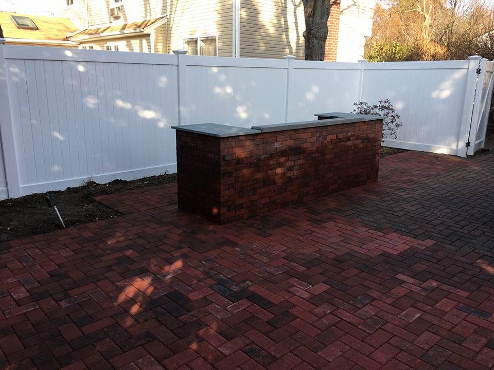 Brick paver patio with brick outdoor kitchen counter and bluestone top