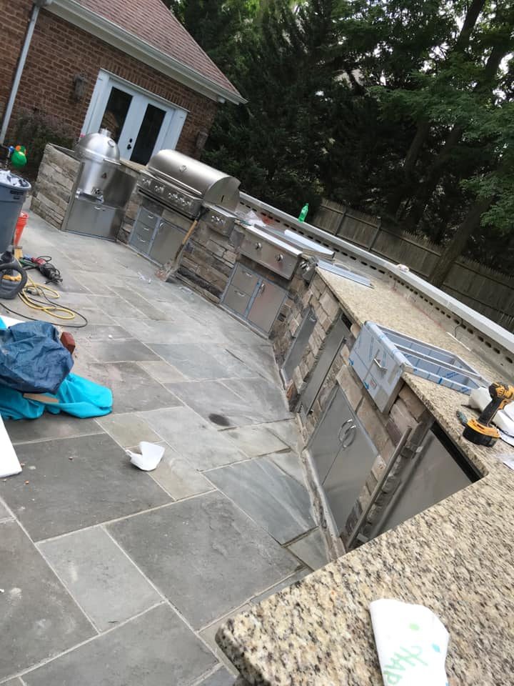 Luxury curved outdoor kitchen with stone veneer and stainless appliances