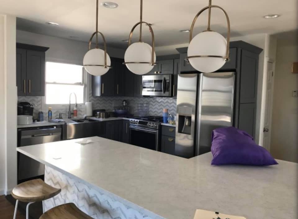 Dark gray kitchen with globe pendant lighting over island