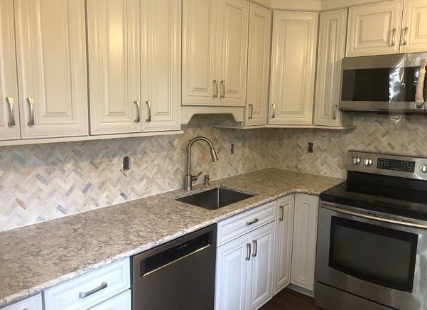 Two-tone kitchen with white upper cabinets and dark island
