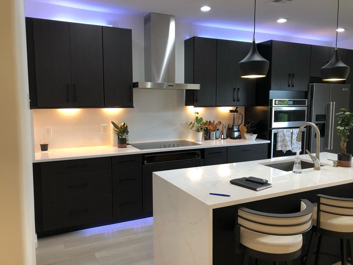 Dark modern kitchen with LED strip lighting under upper cabinets