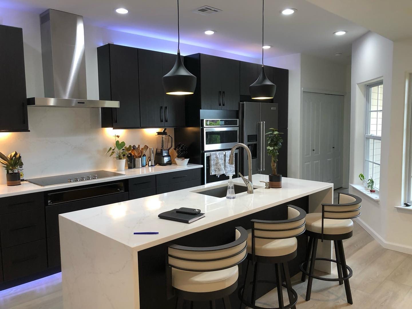 Dark modern kitchen renovation — alternate angle with waterfall island