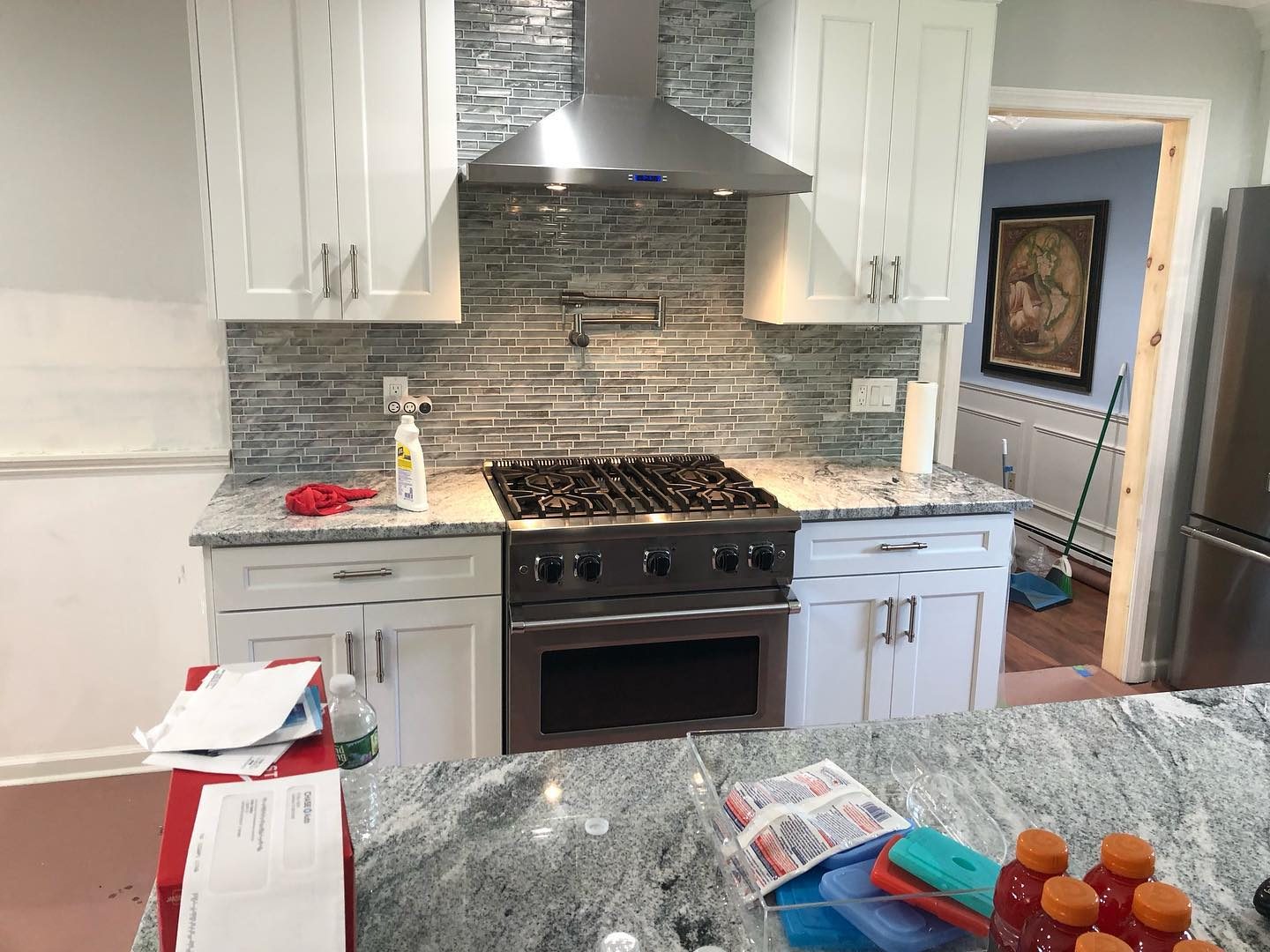 White kitchen with mosaic backsplash — view toward dining area