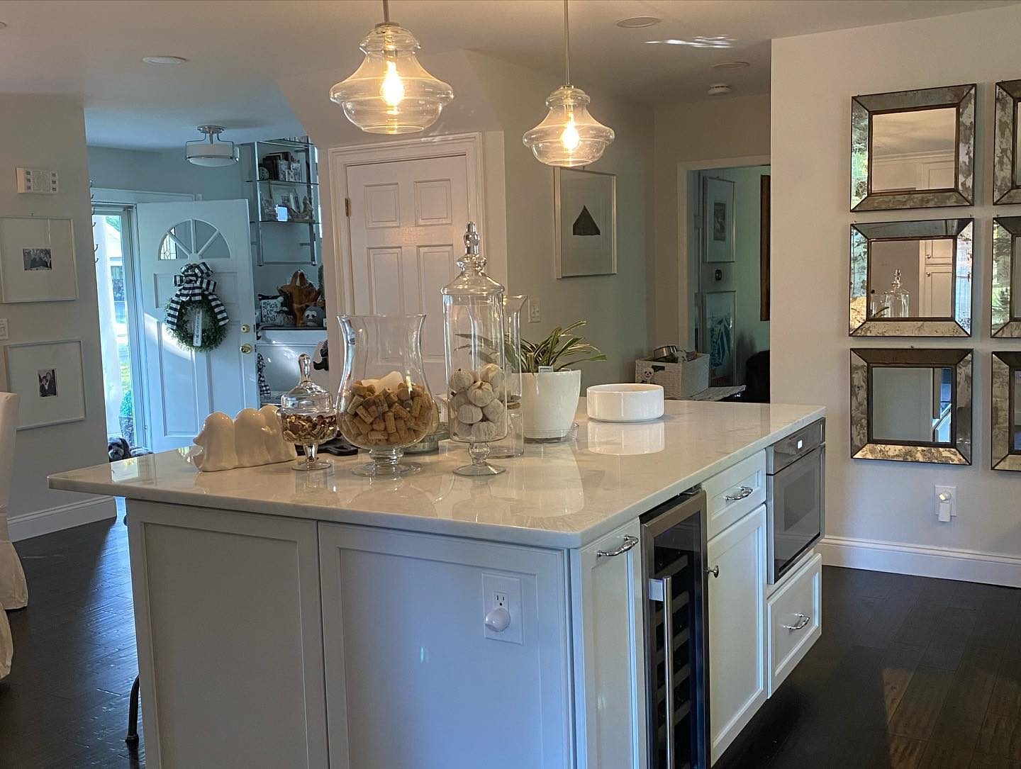 White kitchen with upper glass-front cabinets and quartz countertops
