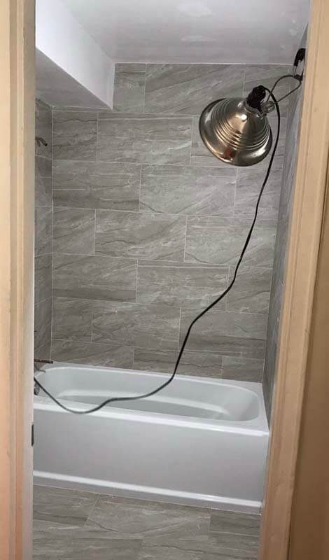 Bathtub and shower surround with gray tile — West Babylon, NY