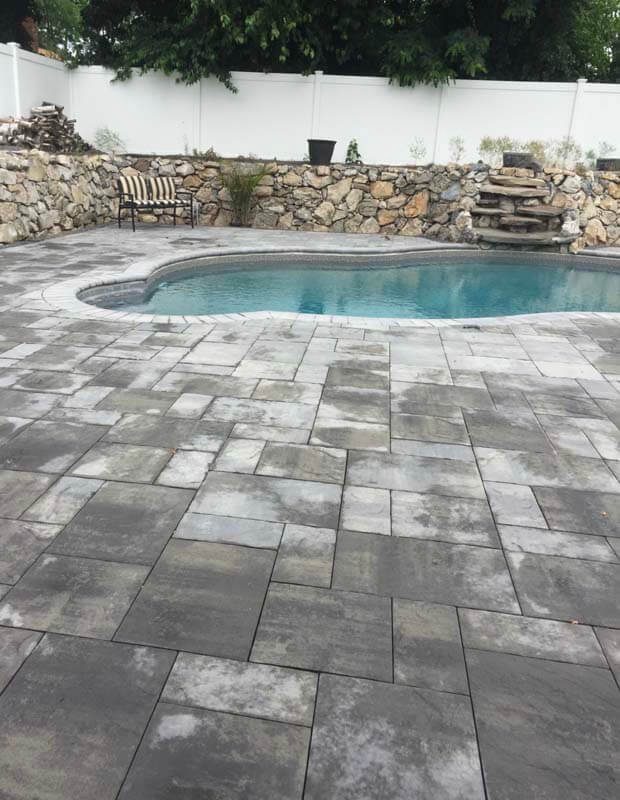Kidney pool with paver surround and stone wall — West Babylon, NY